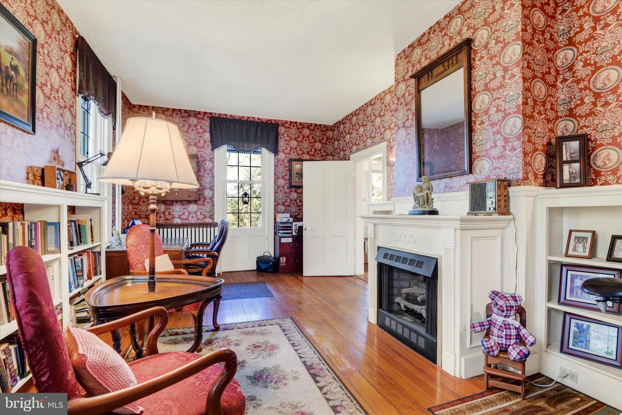 6739 South Clifton Road Frederick, MD 21703 - Photo 12 of 49 a living room with furniture a fireplace and a book shelf