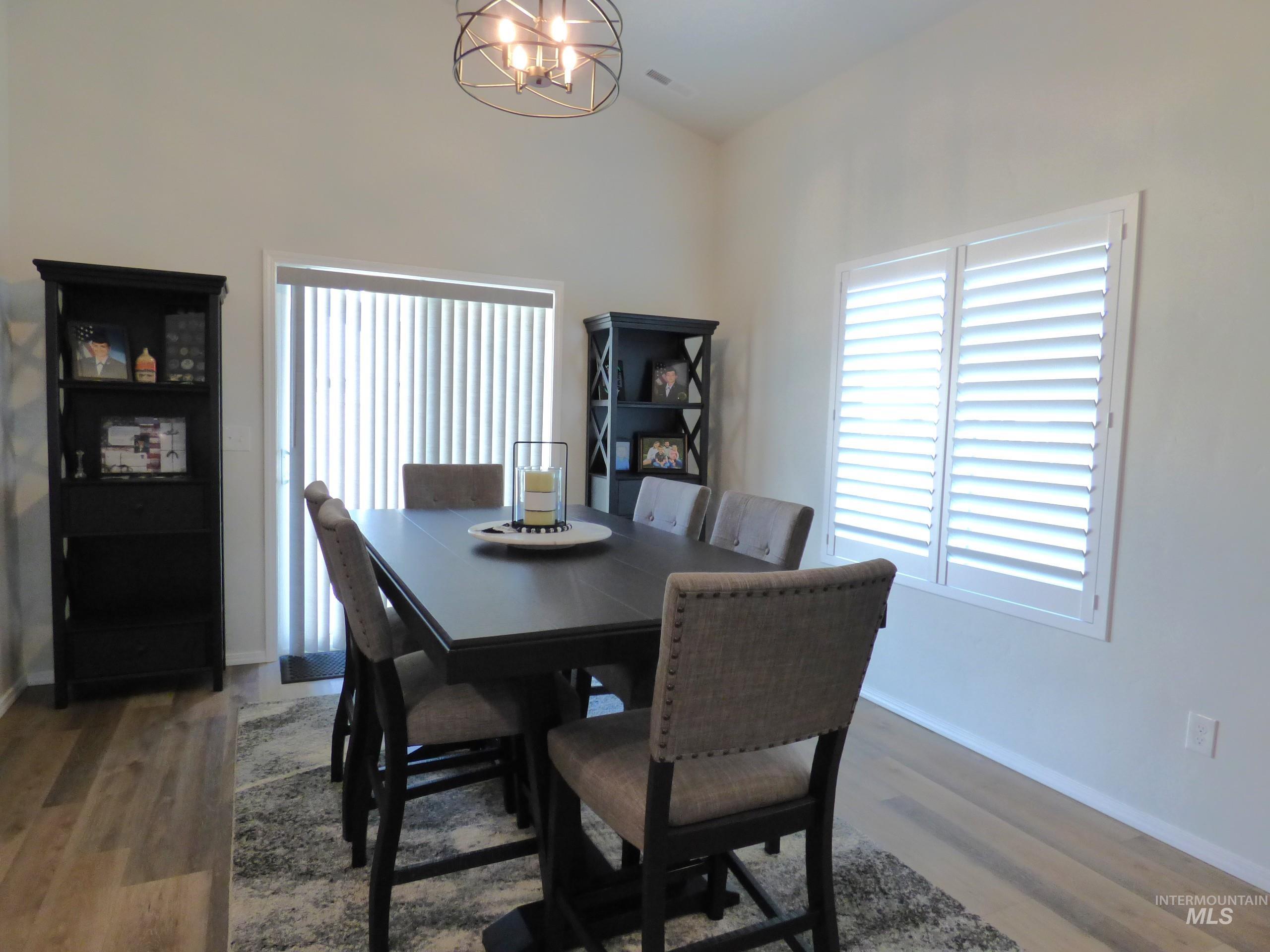 2708 East Buckaroo Drive Kuna, ID 83634 - Photo 8 of 48 Dining area featuring vaulted ceilings, wood-finish flooring, and white plantation shutters