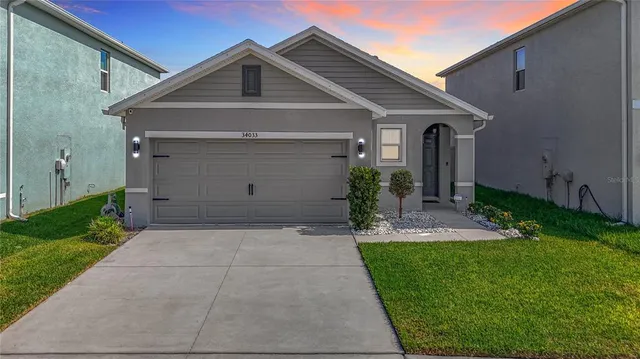 a front view of a house with a yard and garage