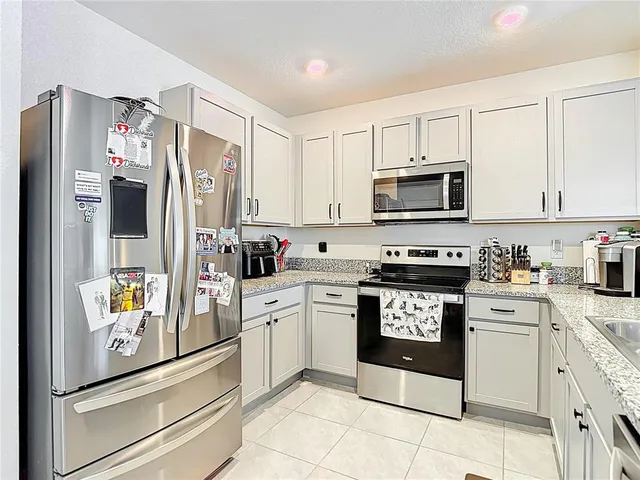 a kitchen with stainless steel appliances granite countertop a refrigerator stove and sink