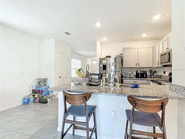 a kitchen with sink a stove and chairs