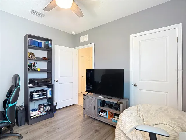 a bedroom with furniture and a flat screen tv