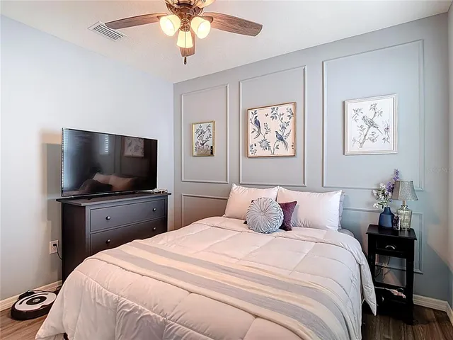 a bedroom with a large bed and a flat tv screen on dresser