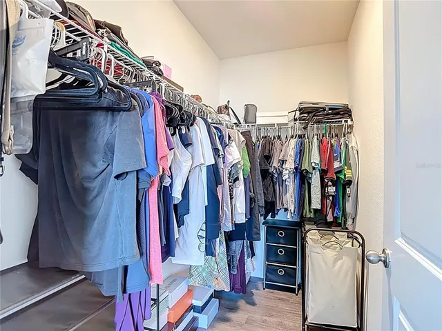 a view of walk in closet with clothes