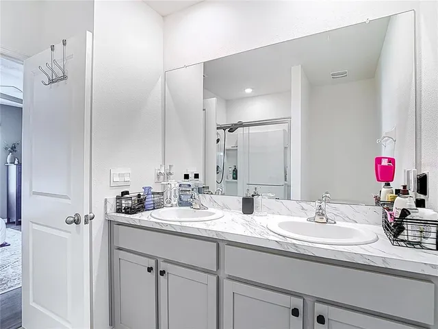 a bathroom with double sink and a mirror