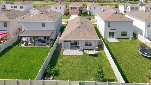 an aerial view of a house with swimming pool patio and yard