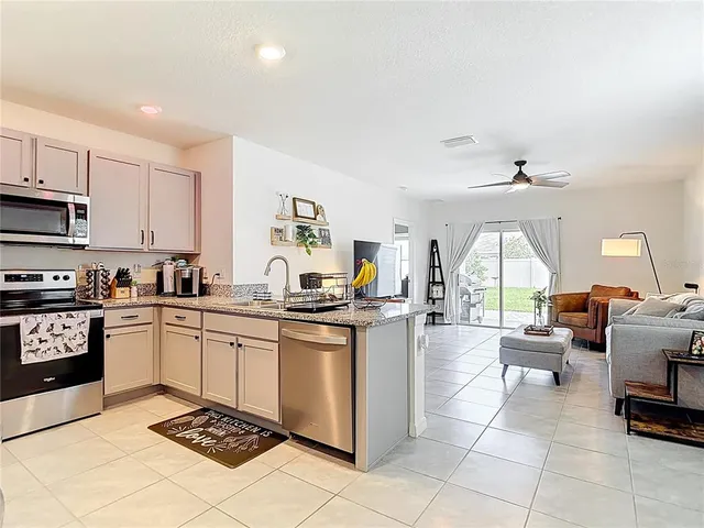 a kitchen with stainless steel appliances kitchen island granite countertop a sink and cabinets