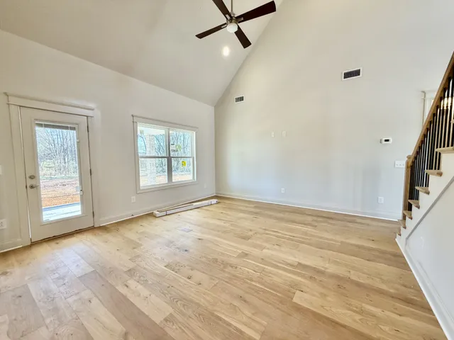 an empty room with a window and a fan