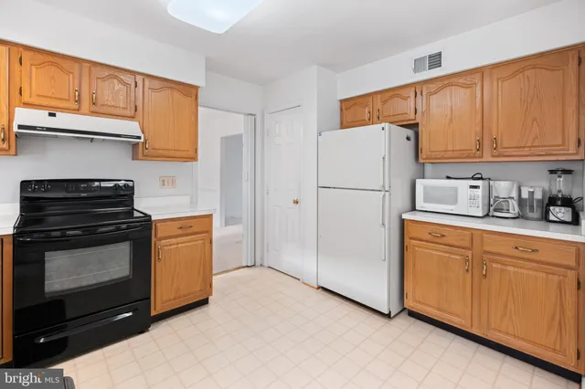 a kitchen with granite countertop a refrigerator stove top oven a sink and dishwasher