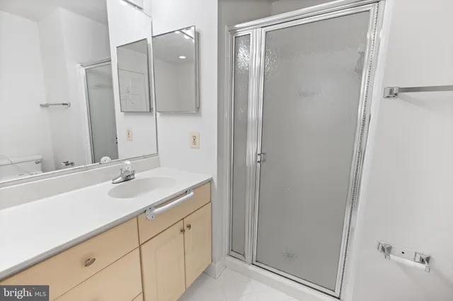 a bathroom with a shower sink and mirror
