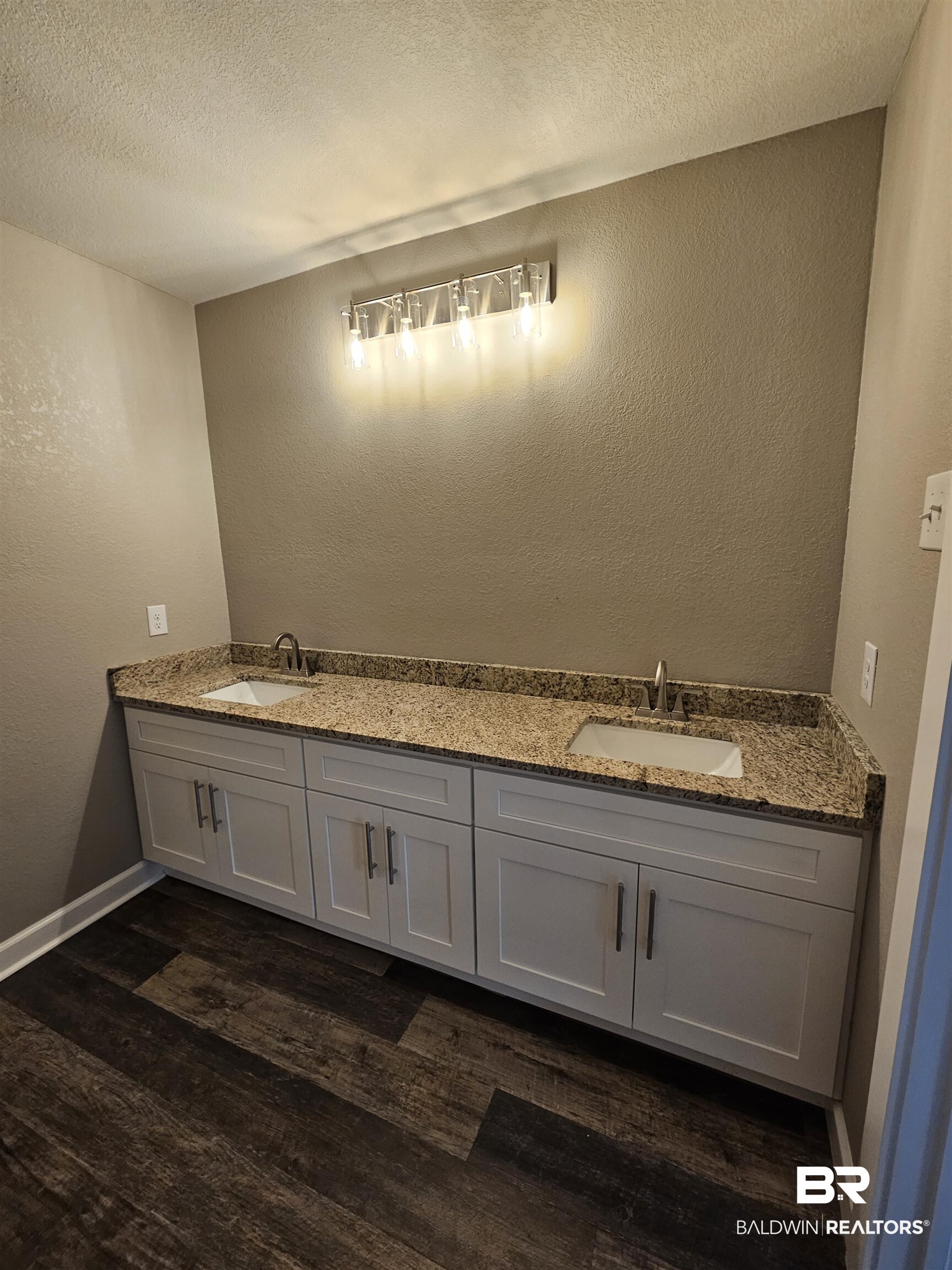 138 Wicker Way Daphne, AL 36526 - Photo 24 of 32 Bathroom with a textured wall, double vanity, a textured ceiling, and dark wood-style floors