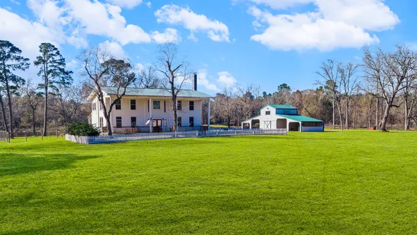 a view of a big yard next to a brick house with a big yard