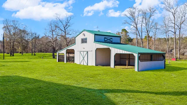 a kitchen with stainless steel appliances kitchen island granite countertop a stove a refrigerator a dining table and chairs with wooden floor