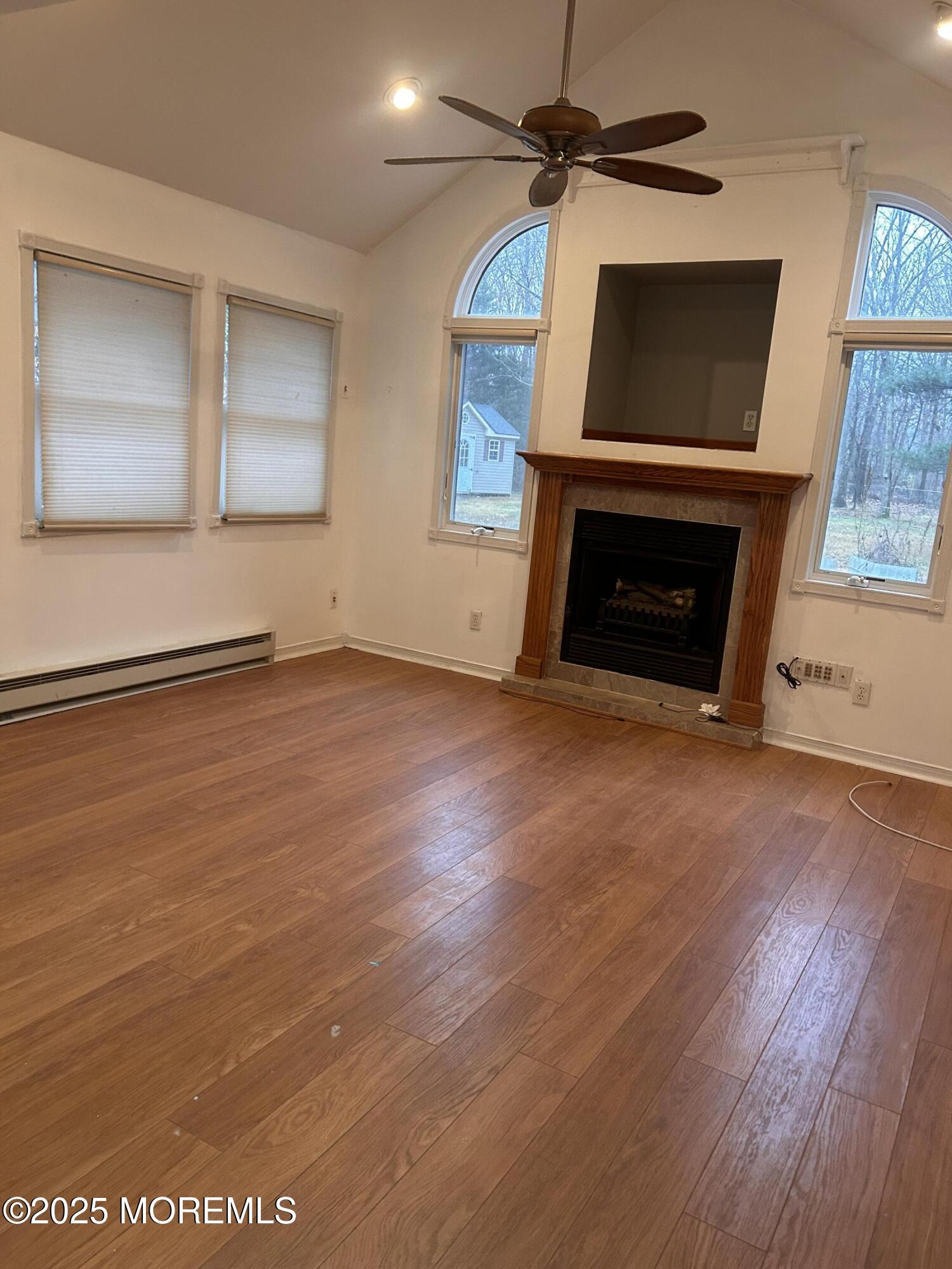 823 Bowman Road Jackson, NJ 08527 - Photo 23 of 27 an empty room with windows fireplace and wooden floor