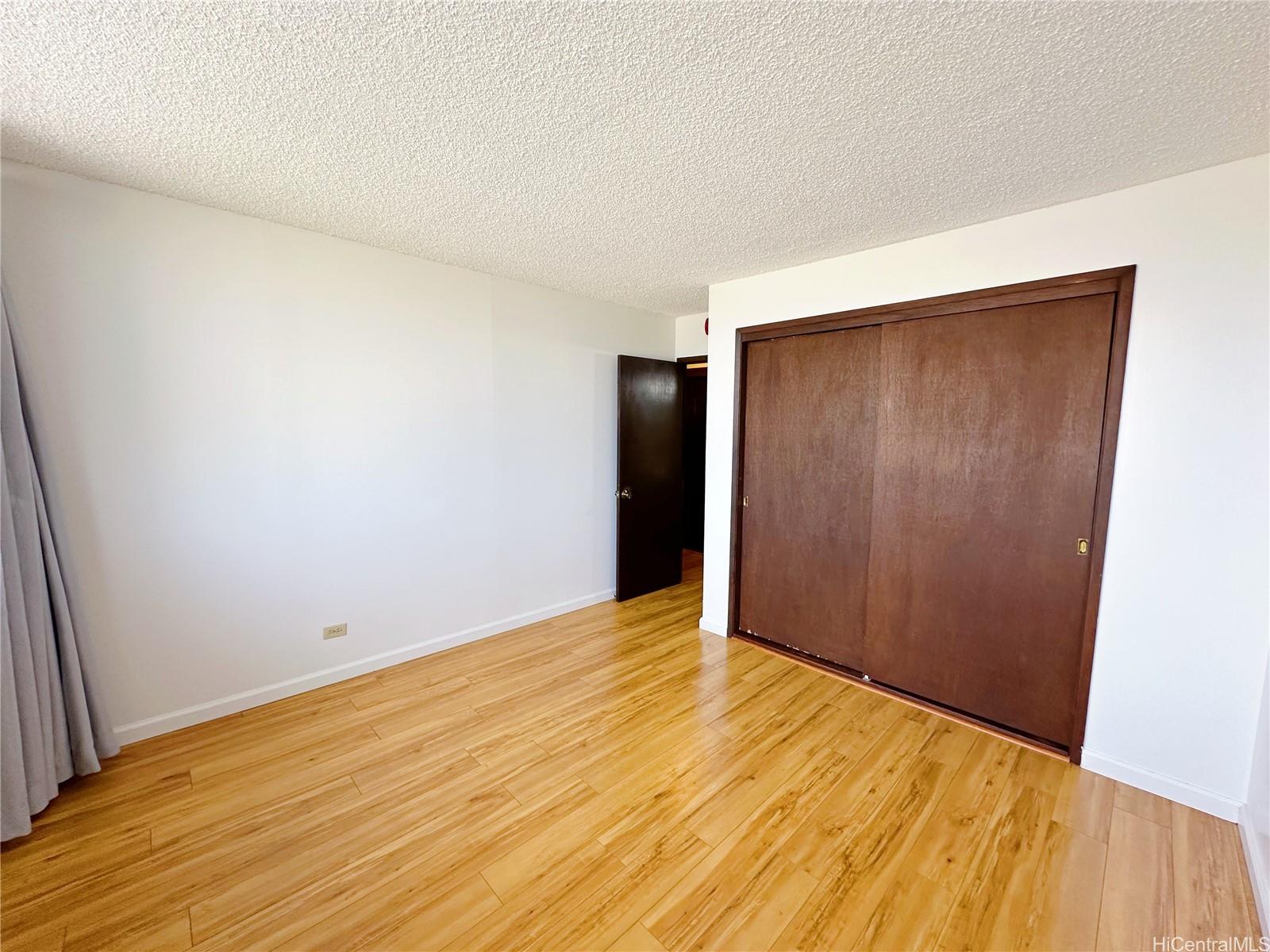 2977 Ala Ilima Street, Unit 809 Honolulu, HI 96818 - Photo 9 of 14 a view of an empty room with wooden floor