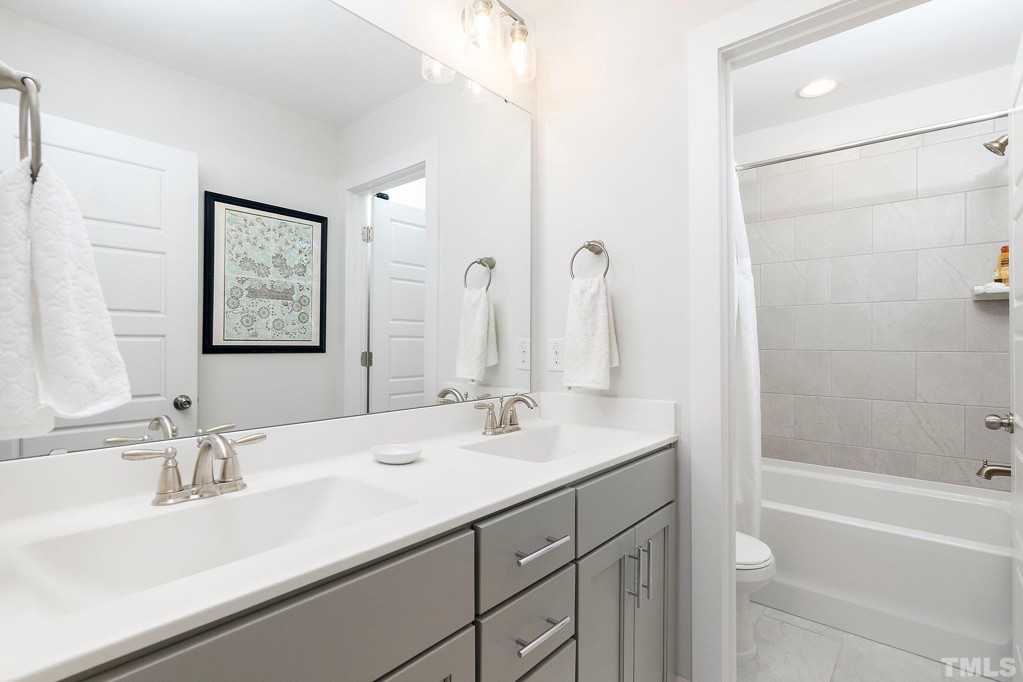 1510 Concord Street Durham, NC 27707 - Photo 13 of 17 a bathroom with a double vanity sink mirror double and a bathtub