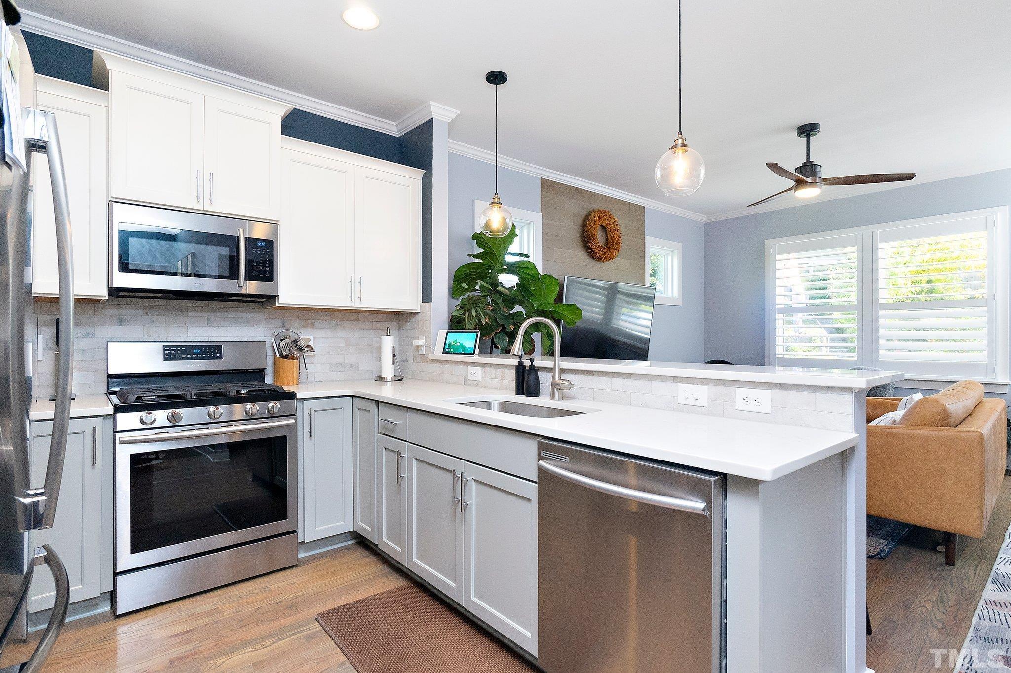1510 Concord Street Durham, NC 27707 - Photo 5 of 17 a kitchen with stainless steel appliances a stove a sink and a microwave