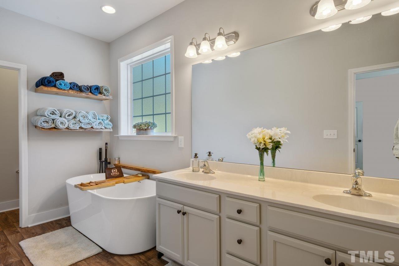 7255 Highway 231 Middlesex, NC 27557 - Photo 14 of 27 a bathroom with a double vanity sink and a mirror