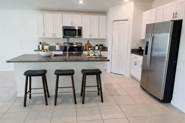 a kitchen with stainless steel appliances granite countertop a refrigerator and a stove top oven