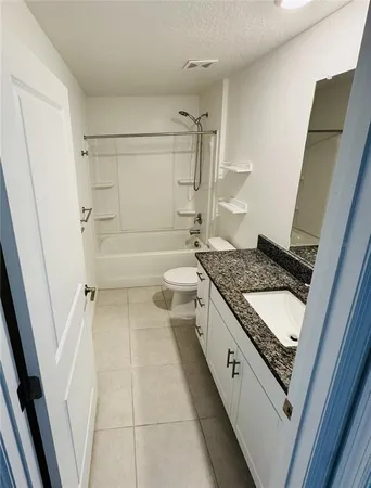 a bathroom with a granite countertop sink a toilet and shower
