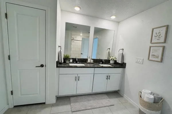 a bathroom with a granite countertop sink and a mirror