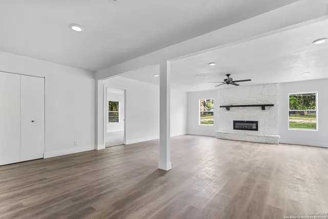 a view of a livingroom with wooden floor and a kitchen