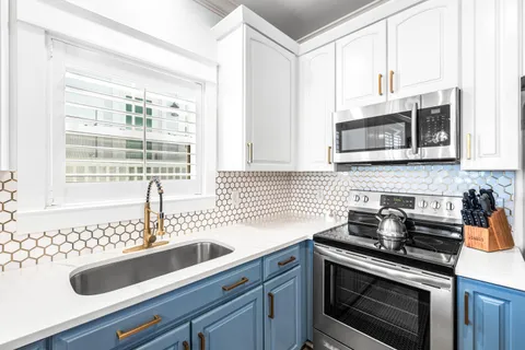 a kitchen with granite countertop a sink stainless steel appliances and cabinets