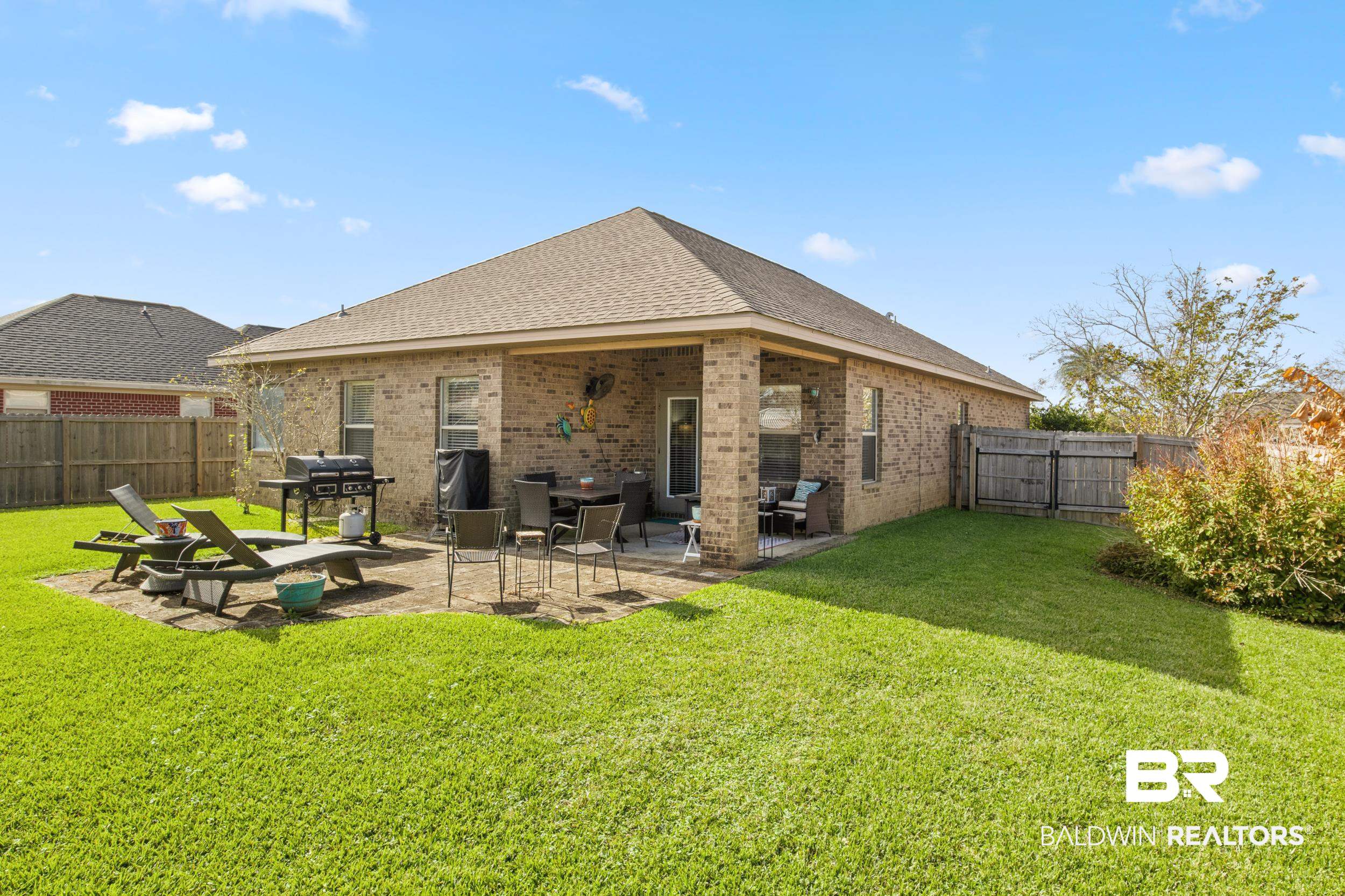 1752 Abbey Loop Foley, AL 36535 - Photo 18 of 21 Rear view of house with a yard and a patio