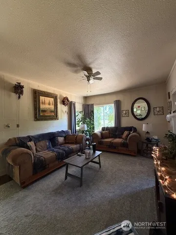 a living room with furniture a large window and a clock