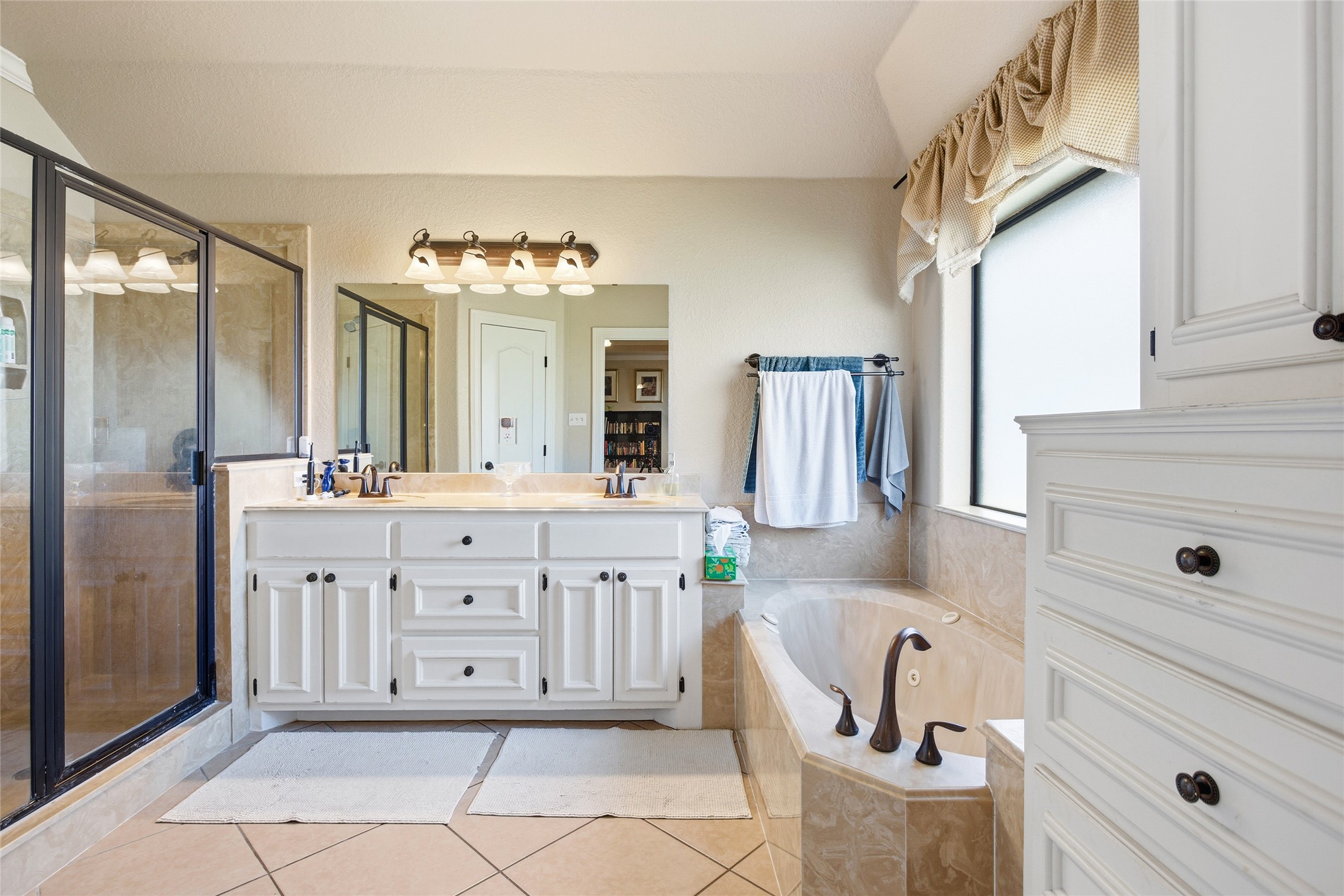 104 Hamilton Clute, TX 77531 - Photo 12 of 25 a spacious bathroom with a double vanity sink a mirror a bathtub and a window