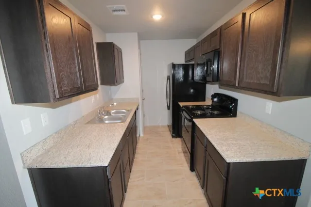 a kitchen with a sink a stove and refrigerator
