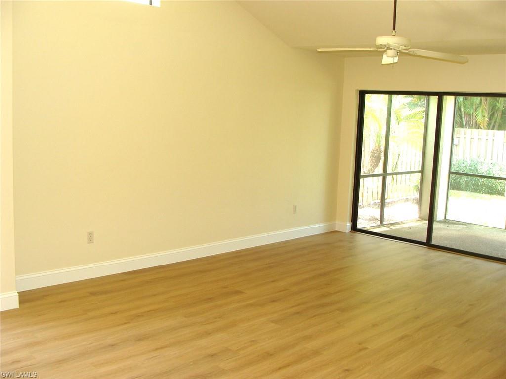 857 Reef Point Circle Naples, FL 34108 - Photo 12 of 27 wooden floor in an empty room with a window
