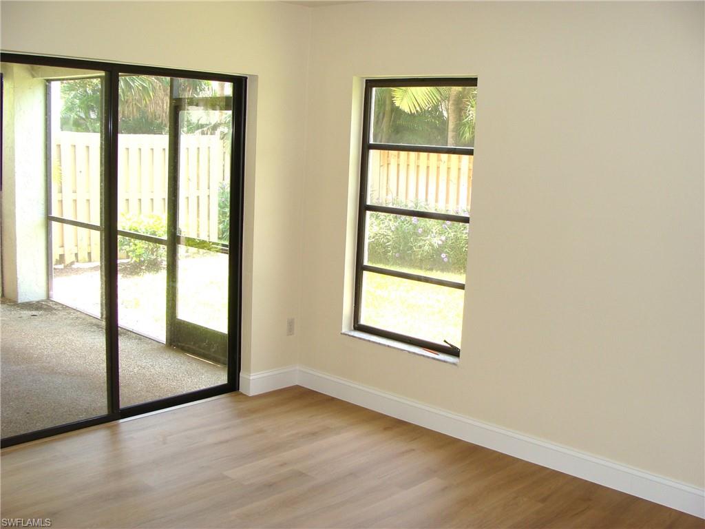 857 Reef Point Circle Naples, FL 34108 - Photo 13 of 27 an empty room with wooden floor and windows