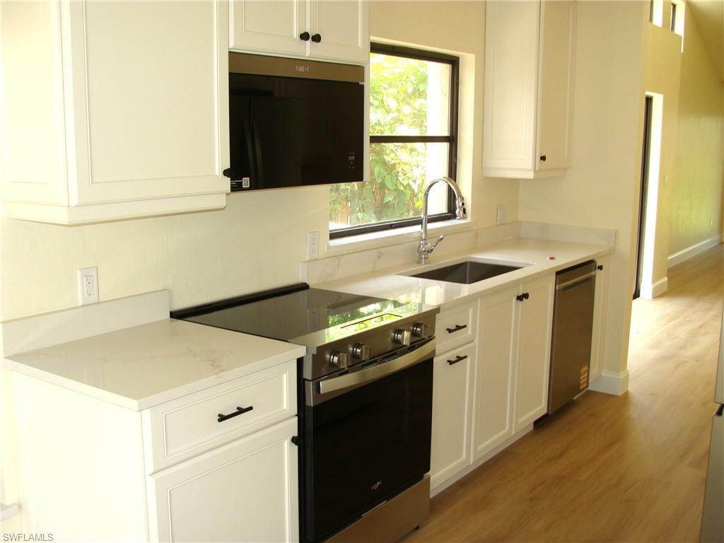 857 Reef Point Circle Naples, FL 34108 - Photo 3 of 27 a kitchen with a stove and a sink