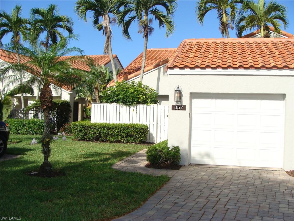 857 Reef Point Circle Naples, FL 34108 - Photo 3 of 8 a front view of a house with a yard and potted plants