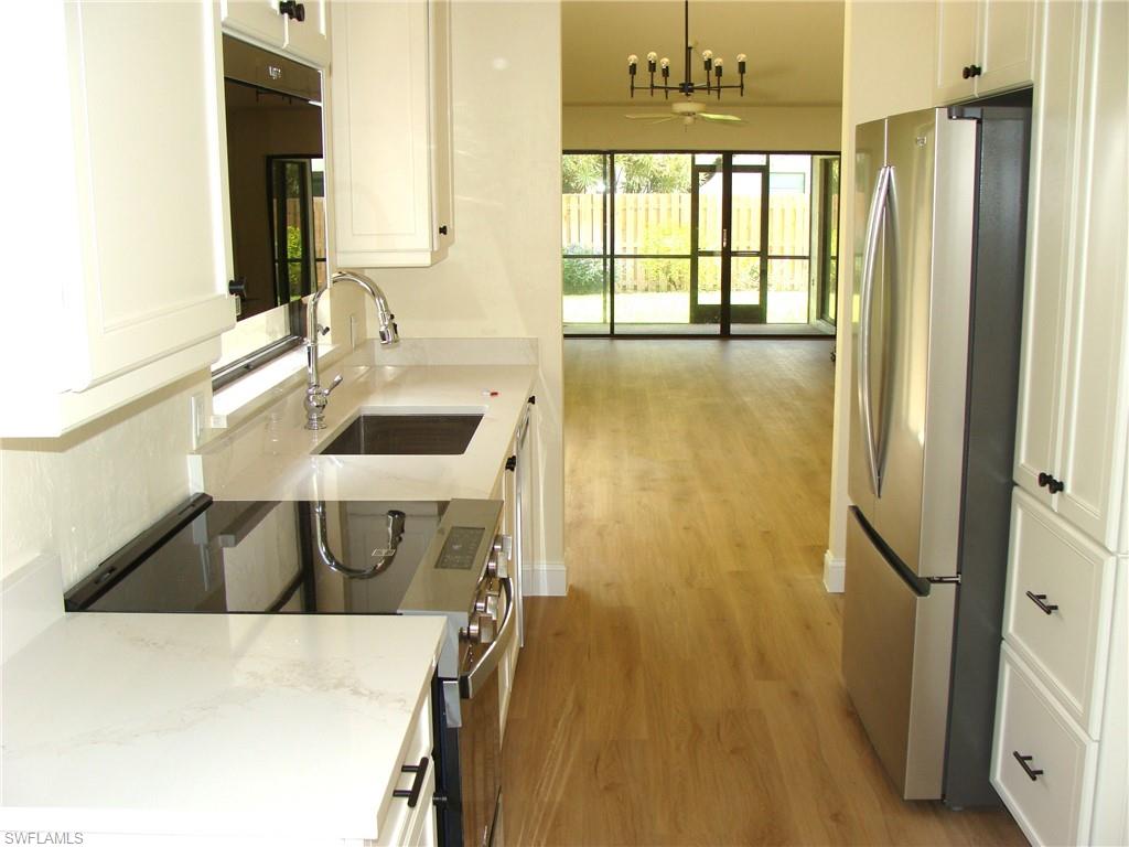 857 Reef Point Circle Naples, FL 34108 - Photo 4 of 27 a bathroom with a sink and a large mirror