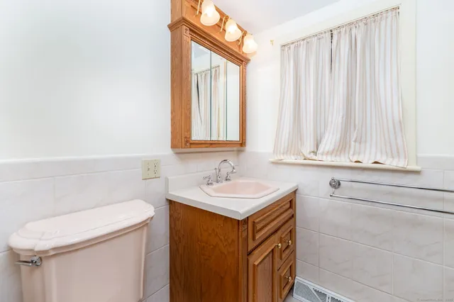 a bathroom with a sink a toilet and a window