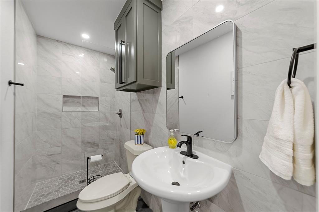 2945 Healey Drive Dallas, TX 75228 - Photo 22 of 38 a bathroom with a sink a toilet and shower