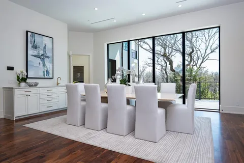 a living room with furniture large window and wooden floor