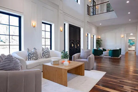 a living room with furniture wooden floor and a large window