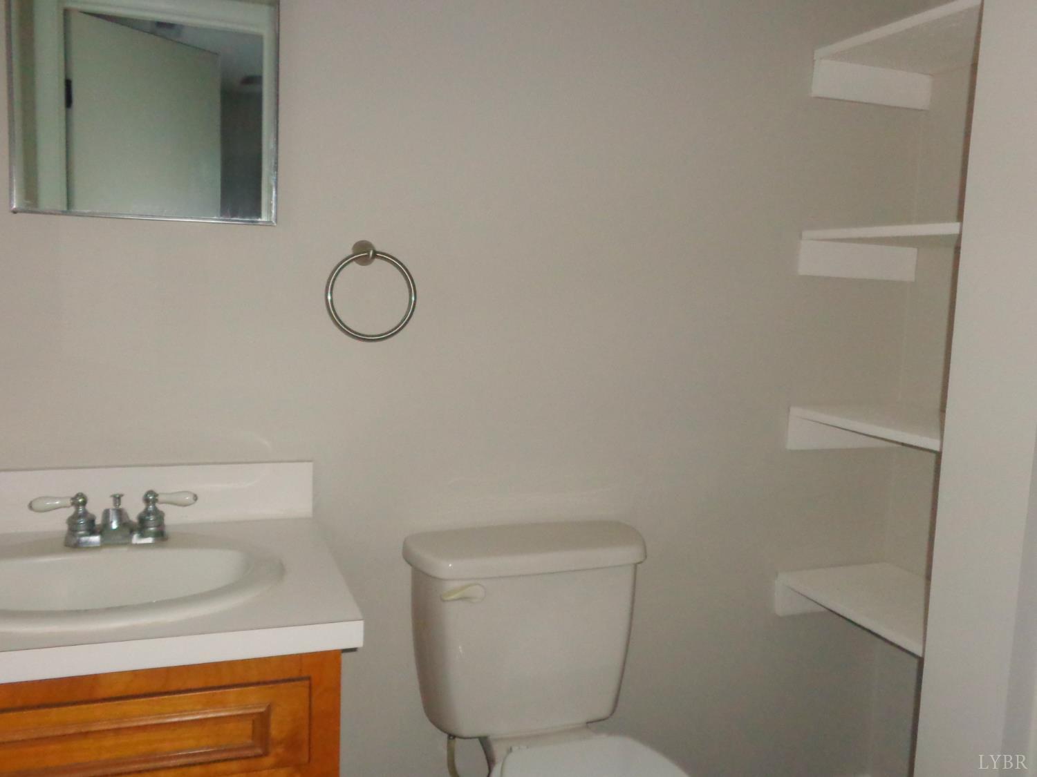 1136 Staunton Hill Road Brookneal, VA 24528 - Photo 11 of 22 a bathroom with a granite countertop toilet sink and mirror