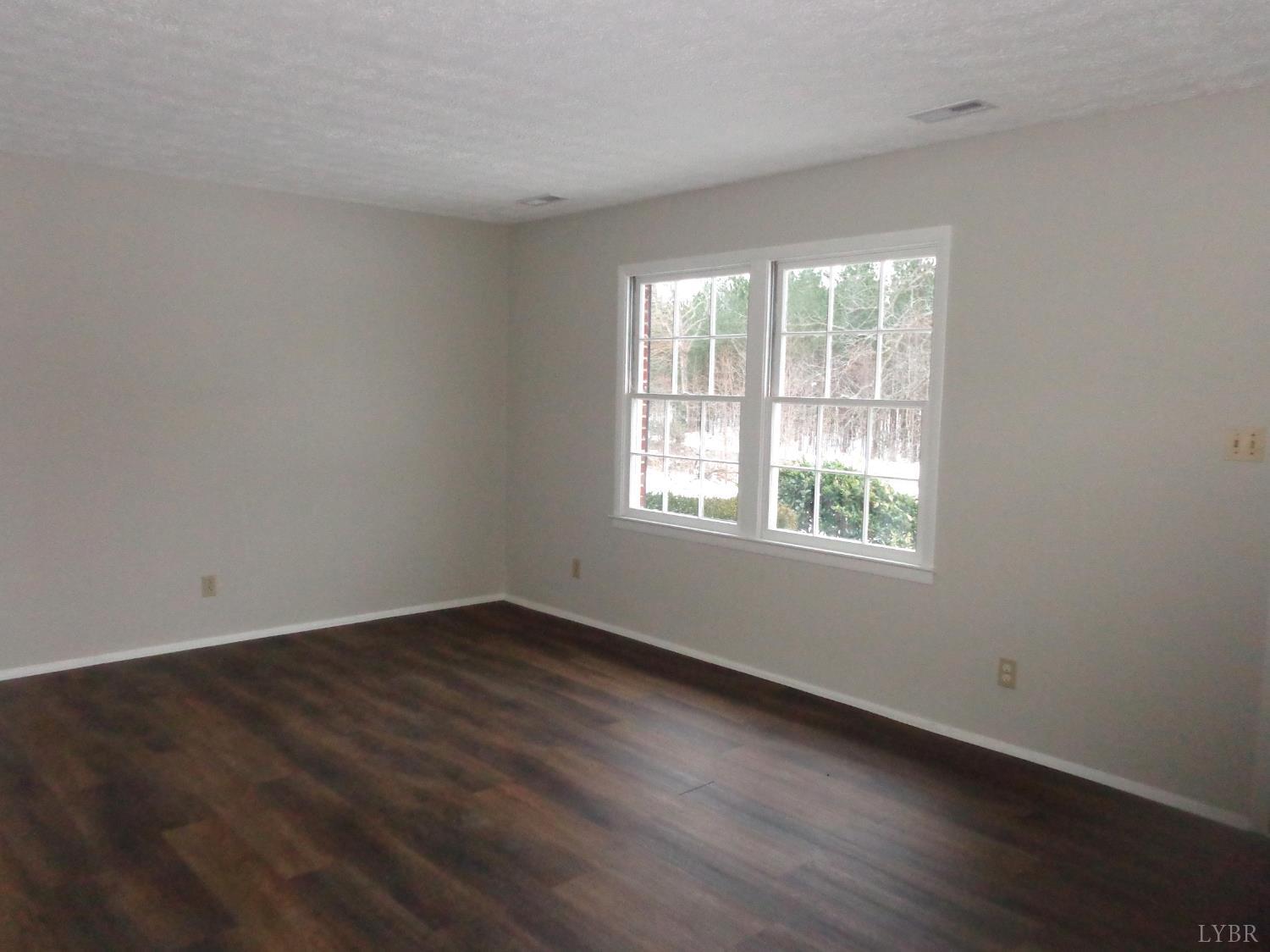 1136 Staunton Hill Road Brookneal, VA 24528 - Photo 15 of 22 an empty room with wooden floor and windows
