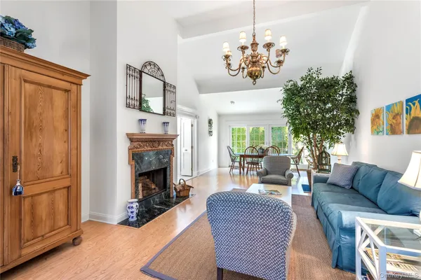 a living room with furniture a chandelier and a fireplace