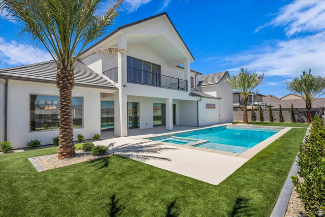 1620 Belayer Drive St. George, UT 84770 - Photo 41 of 51 Expansive backyard featuring a rectangular pool with integrated spa, surrounded by a light-colored paved deck