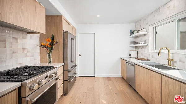a kitchen with sink stove and refrigerator