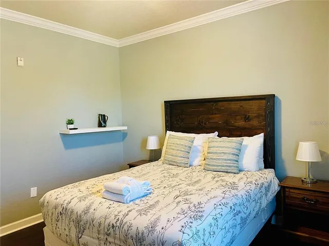 a bedroom with a bed and a lamp on the dresser