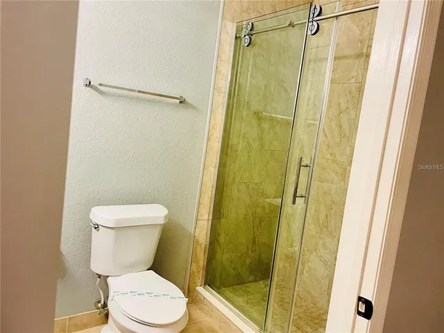 a white toilet sitting next to a shower