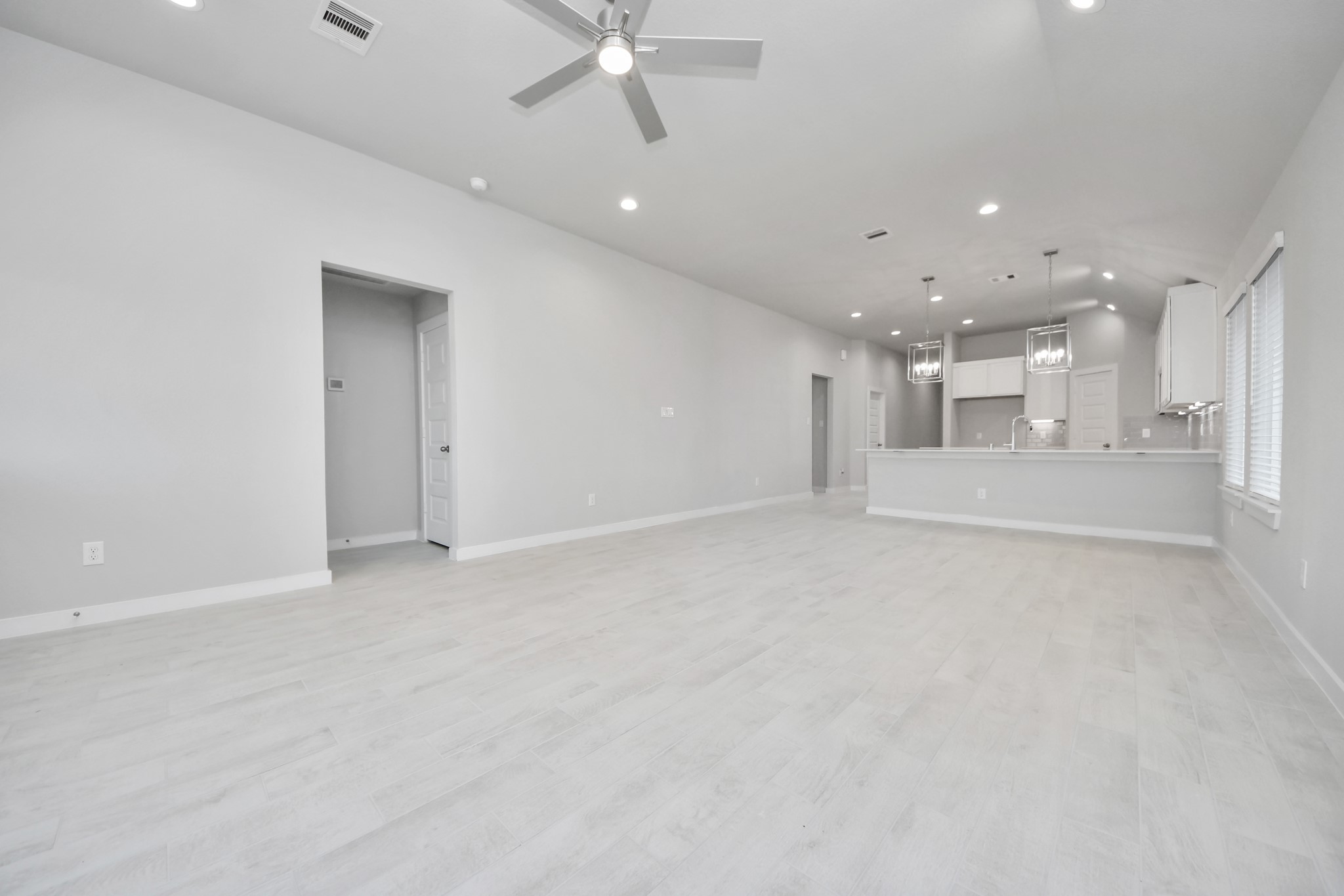 311 Ice Shr Trail Dayton, TX 77535 - Photo 18 of 35 Relax and unwind in this inviting family room, illuminated by abundant natural light streaming in through tall windows, complemented by high ceilings and stunning flooring. Stay comfortable year-round with the gentle breeze from the ceiling fan, creating the perfect atmosphere for family gatherings. Sample photo of completed home with similar floor plan. Actual colors and selections may vary.
