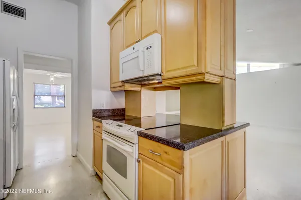 a kitchen with granite countertop a sink and white cabinets