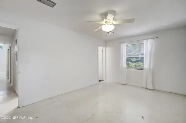 a view of a livingroom with a chandelier fan and a bathroom